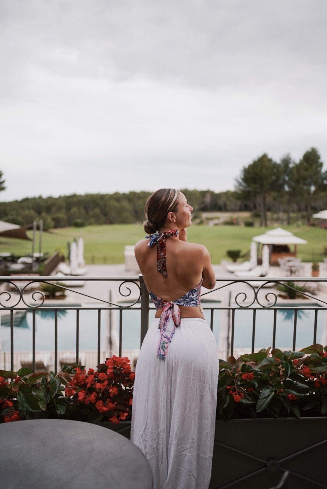 Ludivine au balcon d'un hôtel, face à la piscine et aux jardins