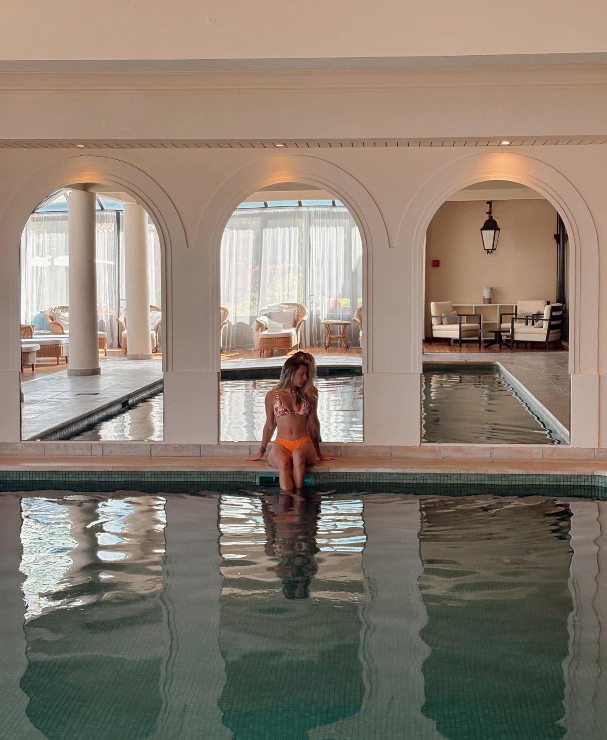 Piscine intérieure d'un hôtel et spa, arches et lumière chaude